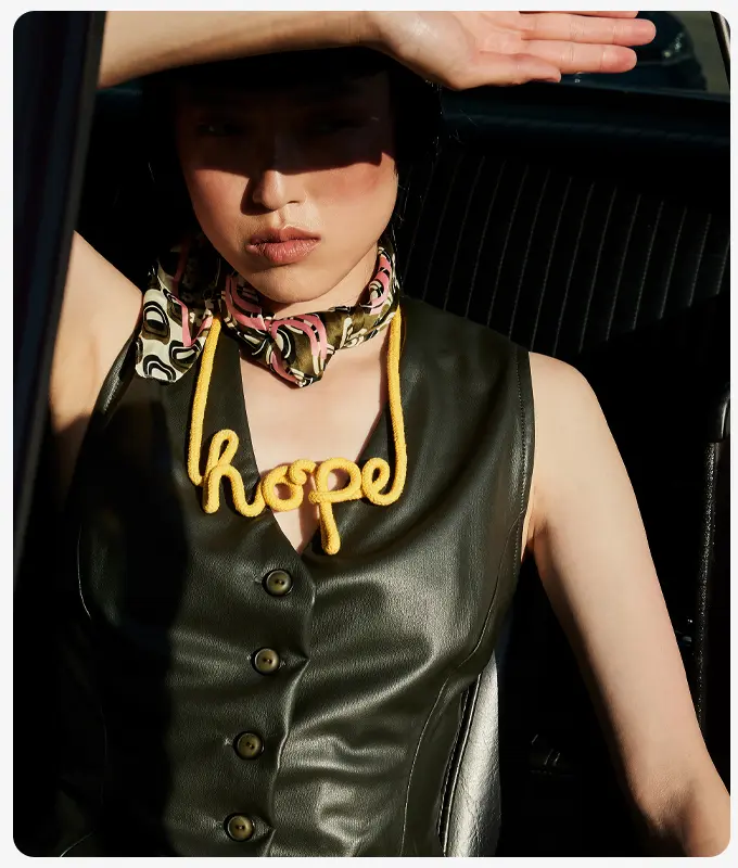 Ana Alcazar Model trägt Kunstlederweste mit Hope-Kette